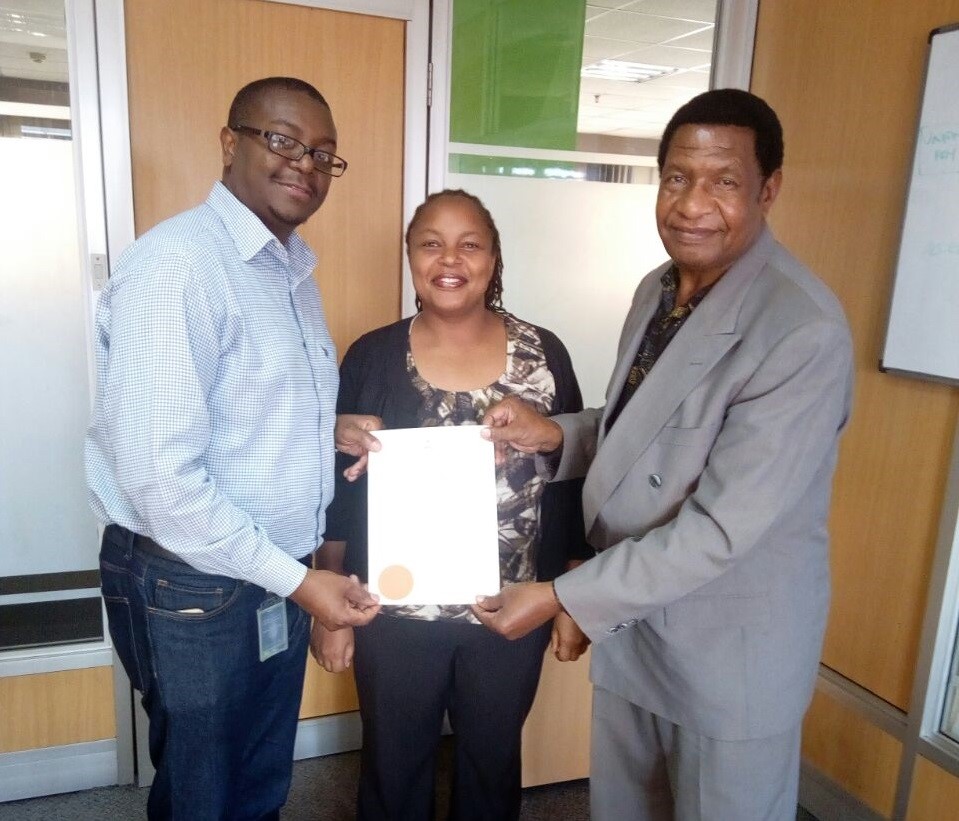 Vincent Aberi of KCB Bank (left) receives Diaspora University Town land 
